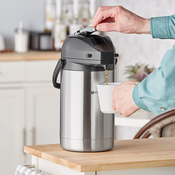 A person pouring coffee from a thermos.