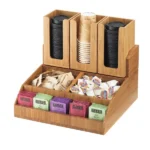 A Cal-Mil 2019-60 Bamboo Condiment Organizer filled with assorted tea bags and compartments containing sugar packets and coffee creamers.