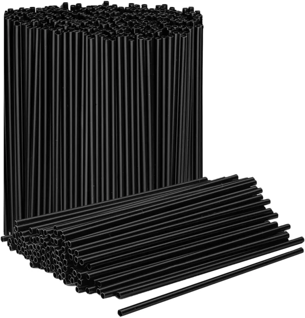 A stack of Berkley Square Stirrer 5" Plastic Stirrers, with several individual stirrers lying horizontally in front of the stack.