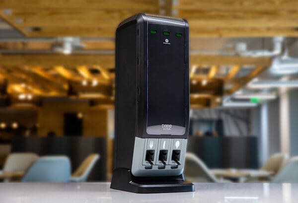 A black Dixie Ultra SmartStock Series-T Fork Refill device on a table in an office with blurred background.