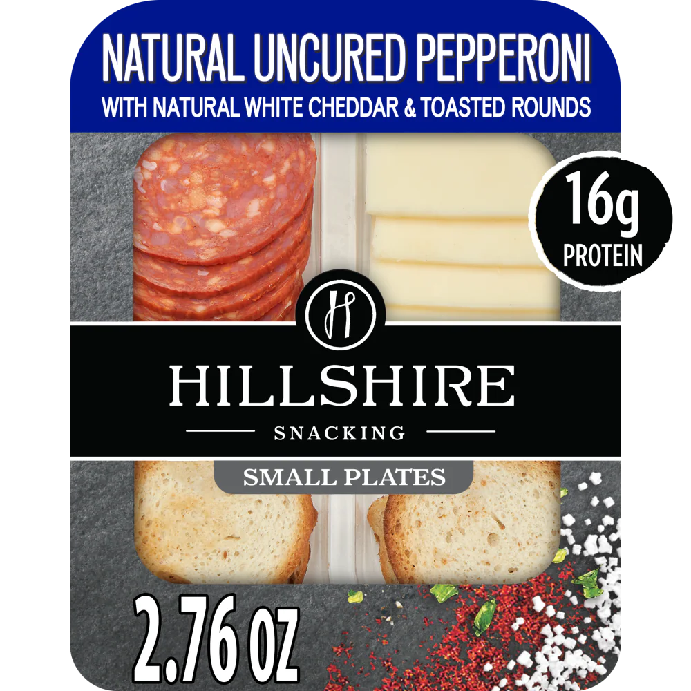 Package of Hillshire Snacking Uncured Pepperoni featuring natural uncured pepperoni, white cheddar cheese, and toasted rounds, highlighted with a black and blue design.